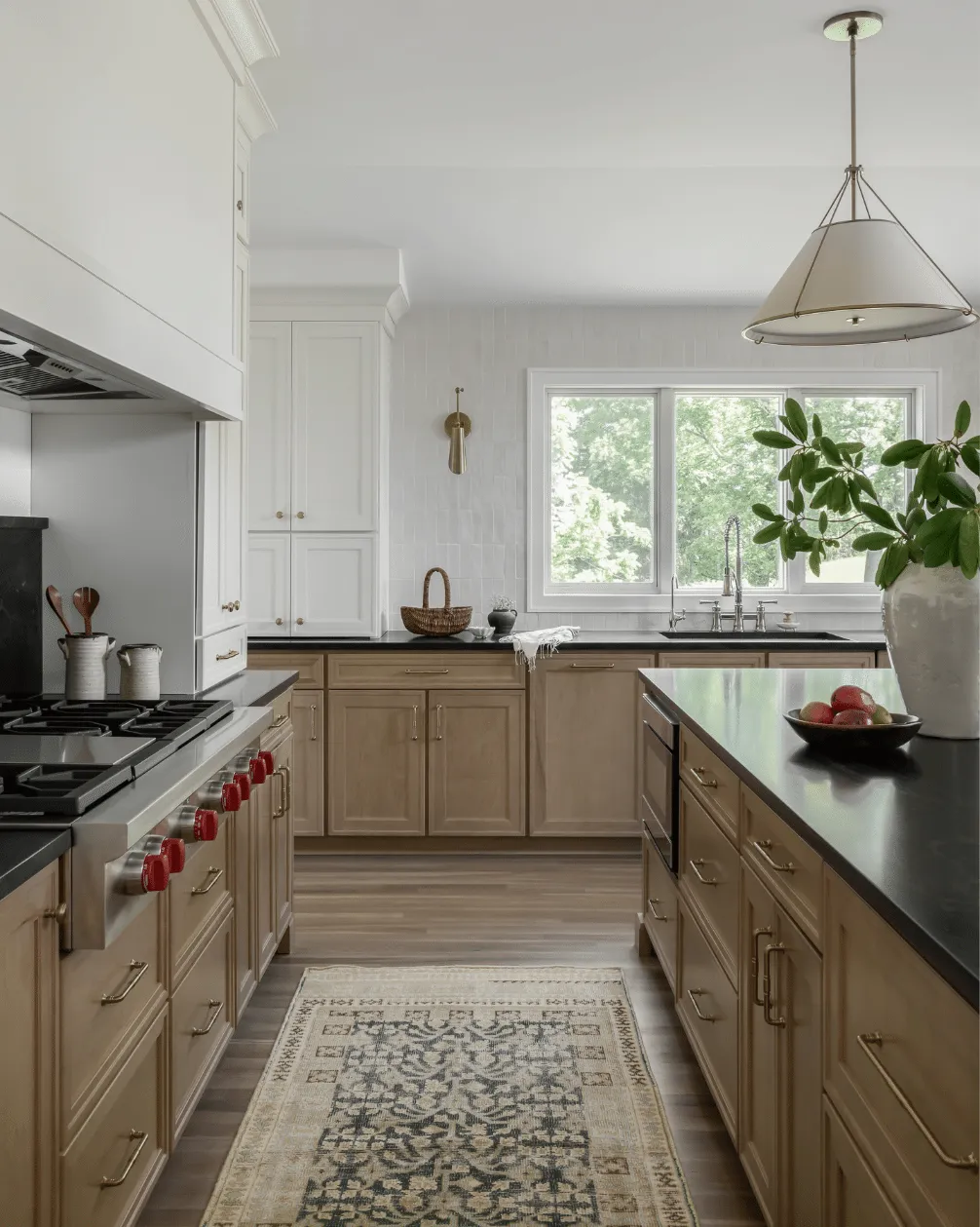 Kitchen with oak cabinetry, a dark countertop and a pendant light